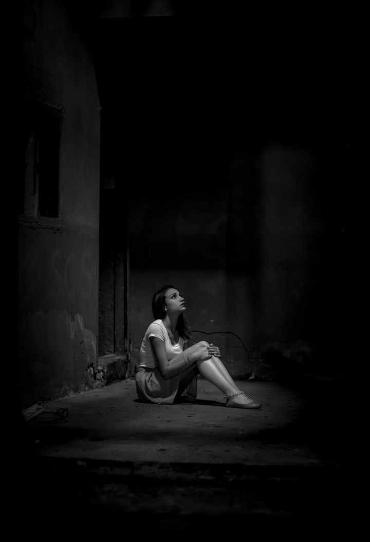 monochrome photo of woman sitting on floor